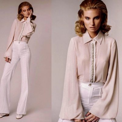 Two models in blush satin blouses and trousers