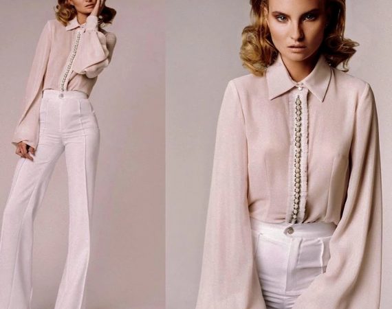 Two models in blush satin blouses and trousers